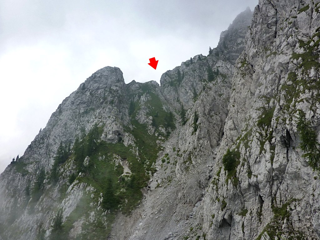 Centro foto: il canale, prima ghiaioso e poi erboso, che porta alla Forcella di Varicla (freccia).