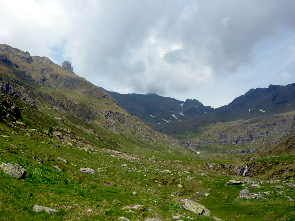 Giungendo al pianoro erboso della baita del Gleno di mezzo. Sfondo, in centro-dx: il p.so di Belviso