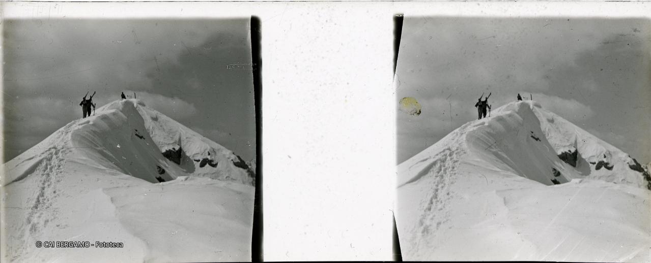 Concorrenti con gli sci a spalla sulla cima del Madonnino