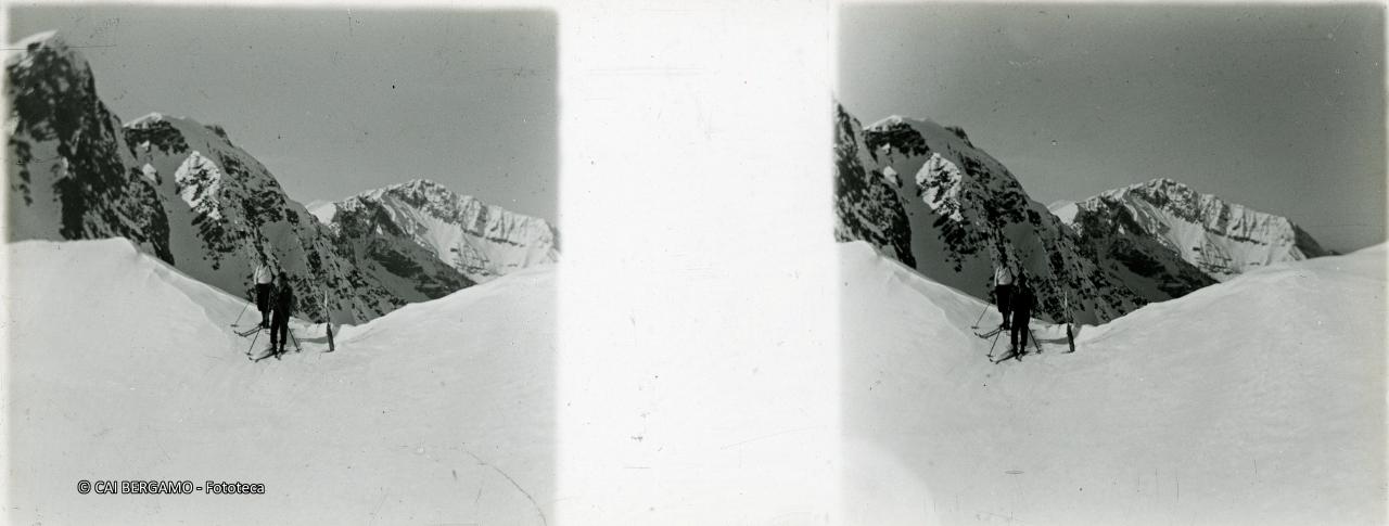 Scialpinisti al passo con retrostante Corno Branchino  e sullo sfondo il Menna
