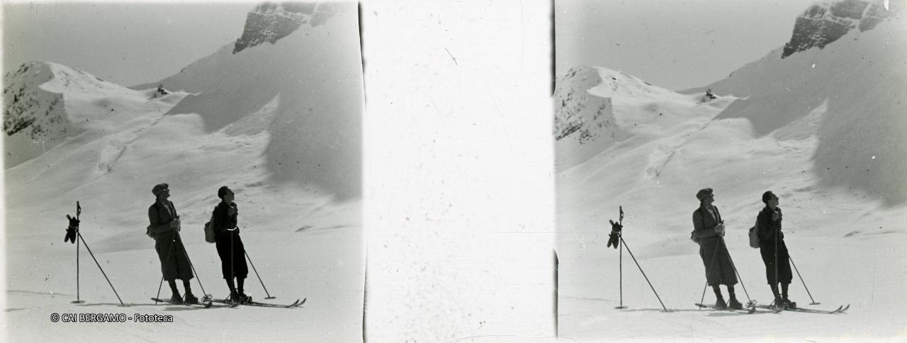 Scialpinisti al passo innevato con l'Arera sulla destra