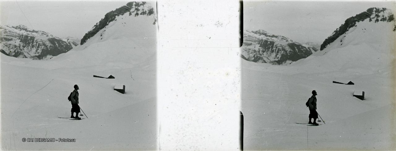 Scialpinista sul pendio sopra baite