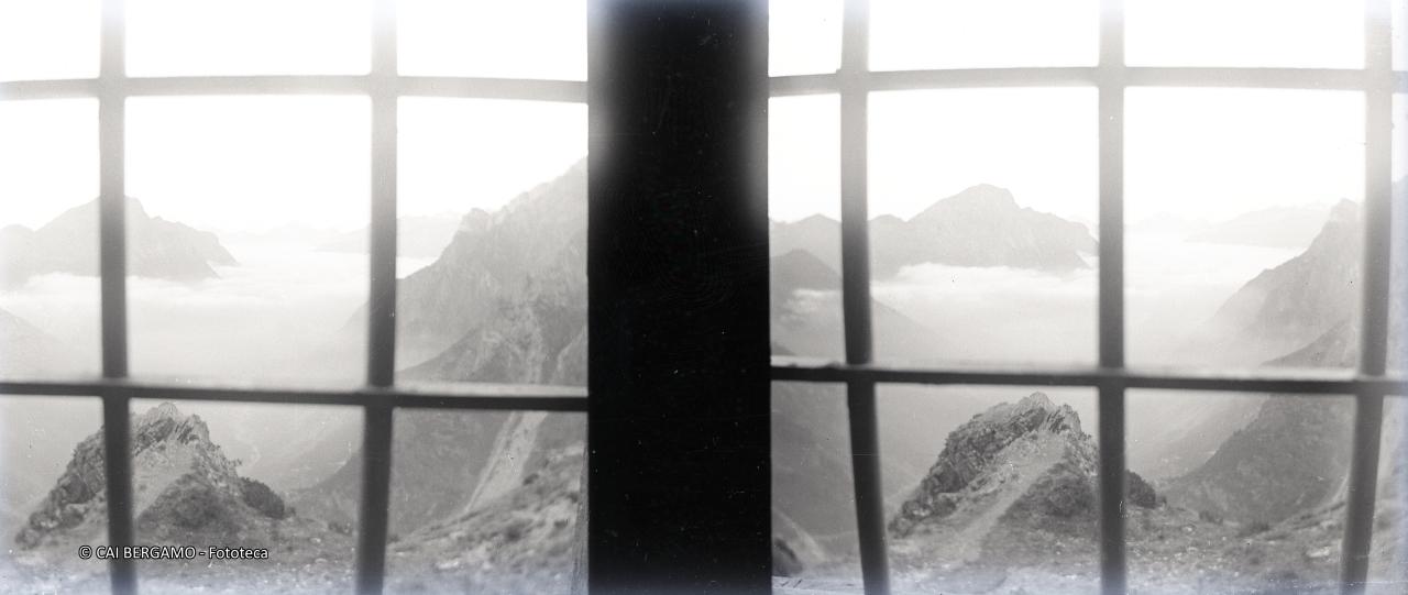 Vista dalla finestra del vecchio rifugio Curò sulla valle immersa nella nebbia con il Vigna Soliva