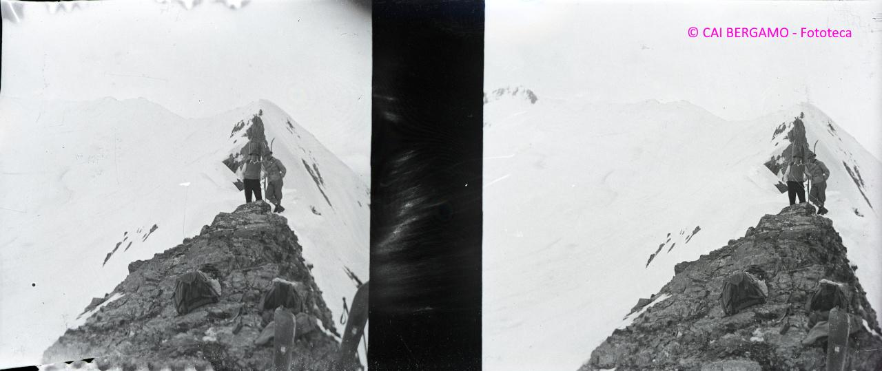 Foto ricordo lungo la cresta, con sci e zaini in primo piano