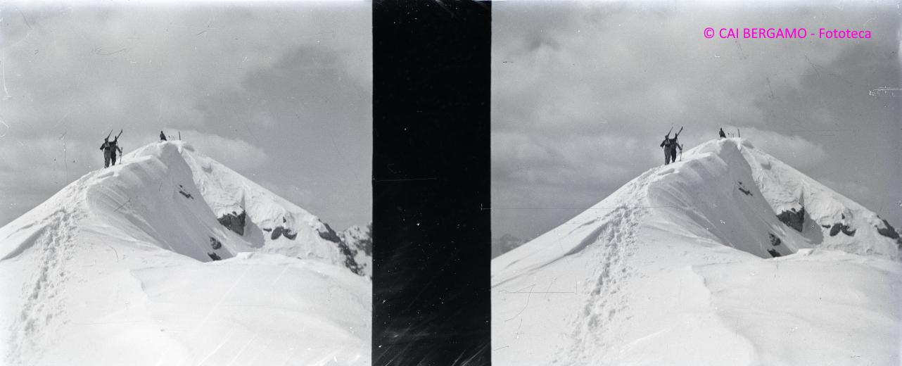 Concorrenti con gli sci a spalla sulla cima del Madonnino