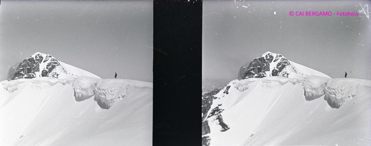 Sciatore sul crinale innevato e ghiacciato con la cima Ombretta sullo sfondo
