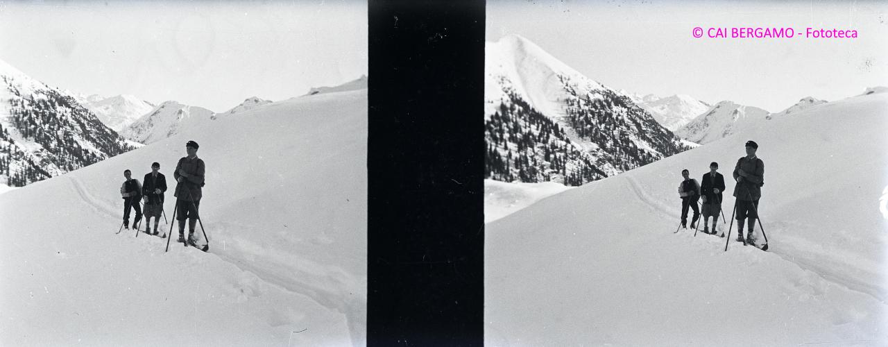 Sciatori in colonna, lungo la traccia nella neve