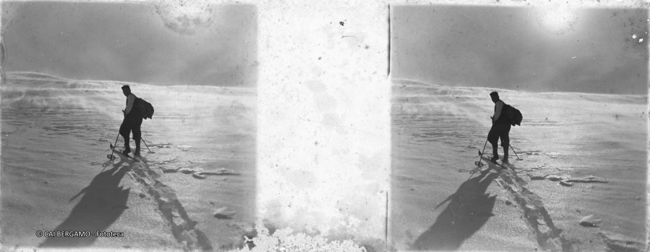 Solitaria salita sugli sci con sole in controluce