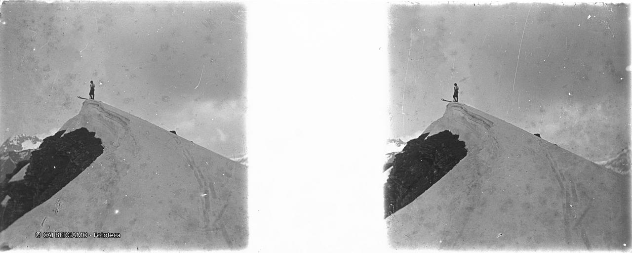 Scialpinista in bilico su cresta di neve