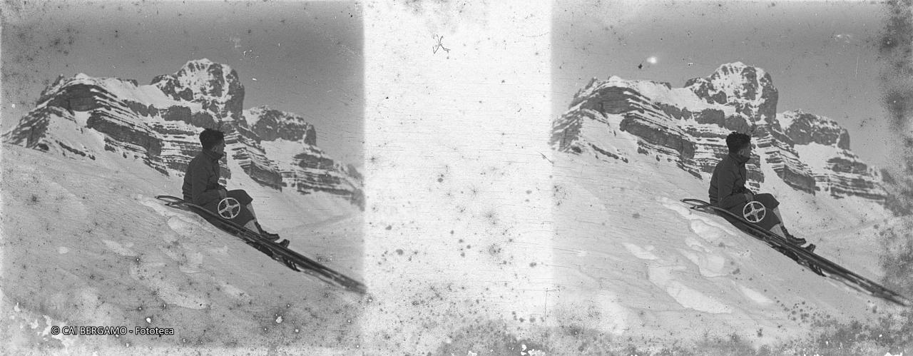 Scialpinista seduto nella neve con alle spalle le Dolomiti