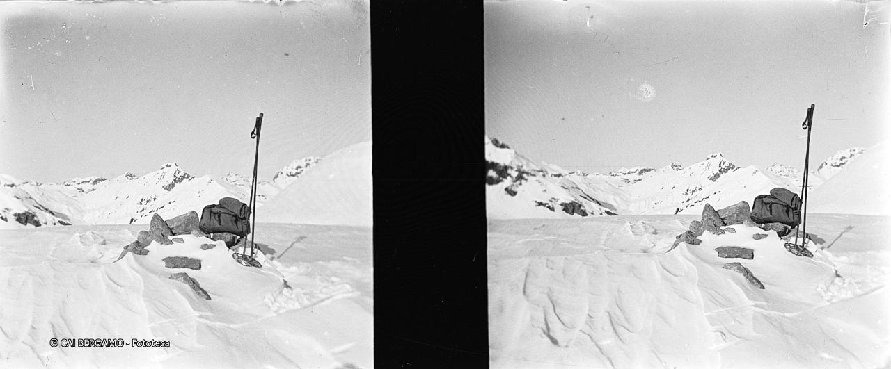 Zaino e bastoncini con vista su cime circostanti