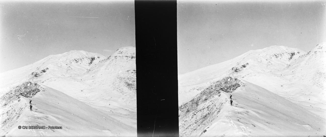 Salendo lungo la cresta ammantata di neve verso il Grem e sullo sfondo il Pizzo Arera