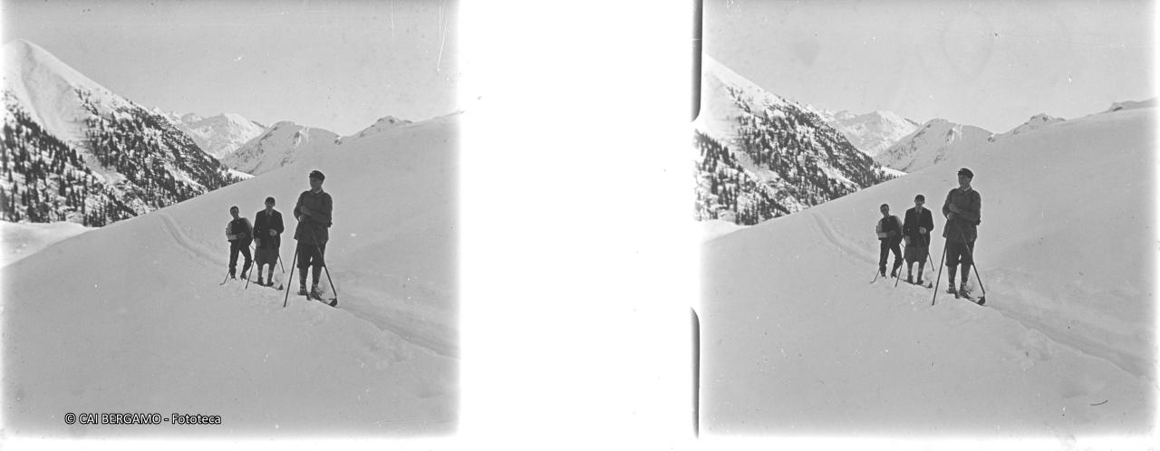 Skiatori in posa su traccia in mezza costa, con il Cadelle sullo sfondo