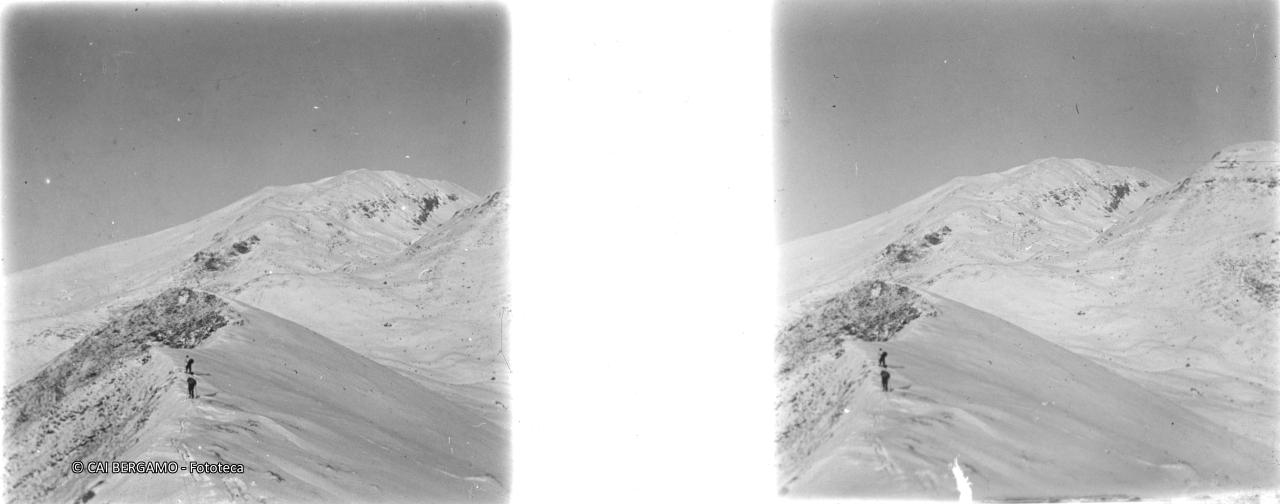 Salendo lungo la cresta ammantata di neve verso il Grem e sullo sfondo il Pizzo Arera