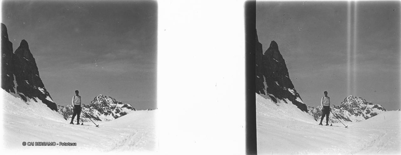 Skiatore salendo dal Val Cerviera sotto il Recastello con il Pizzo Coca sullo sfondo