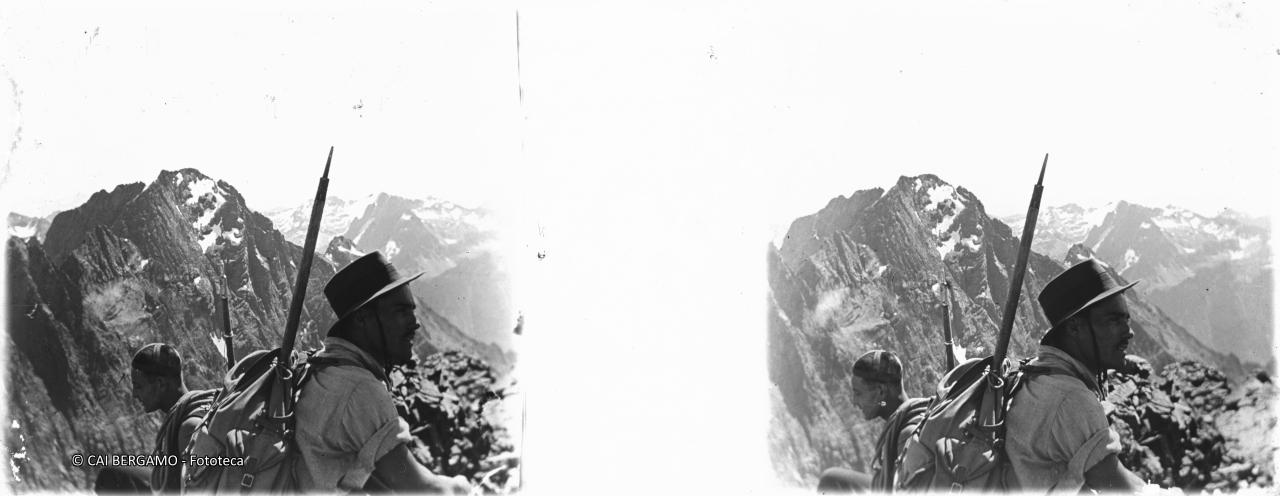 Bel primo piano sul Redorta con zaino in spalla e piccozza e con vista sul Dente di Coca e Pizzo di Coca