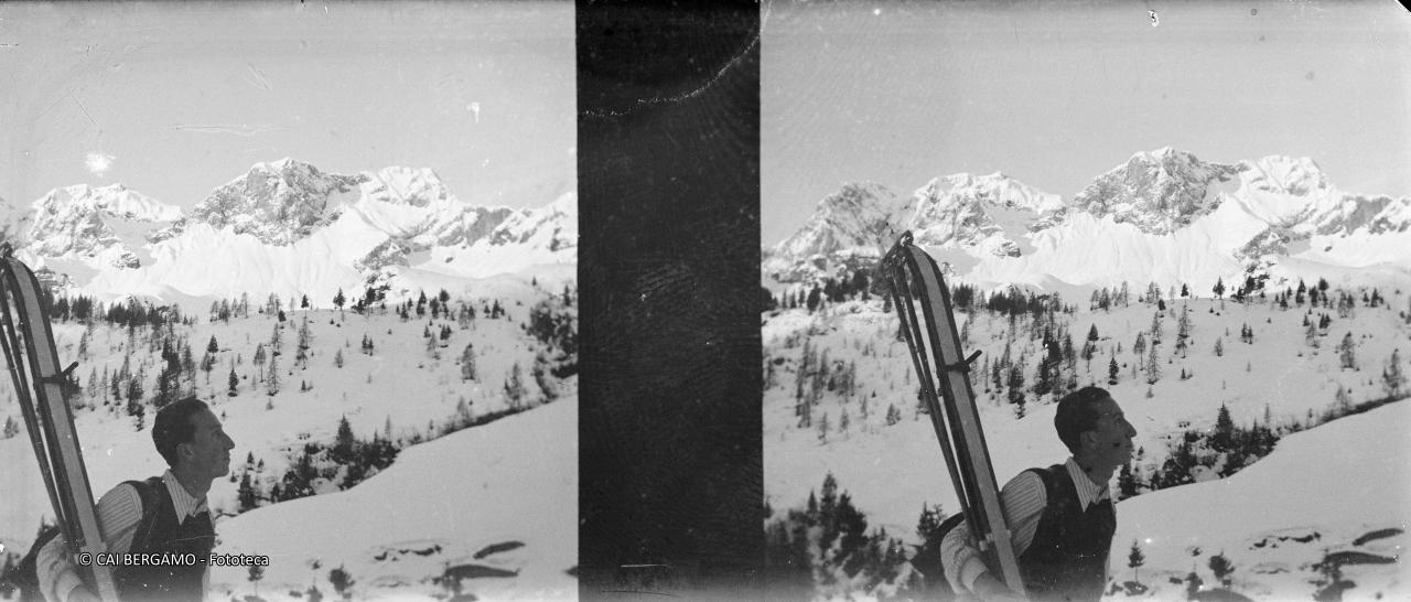 Dal rifugio Alpe Corte vista sul Corna Piana e Pizzo Arera con skialpinista in primo piano con sci con pelli 