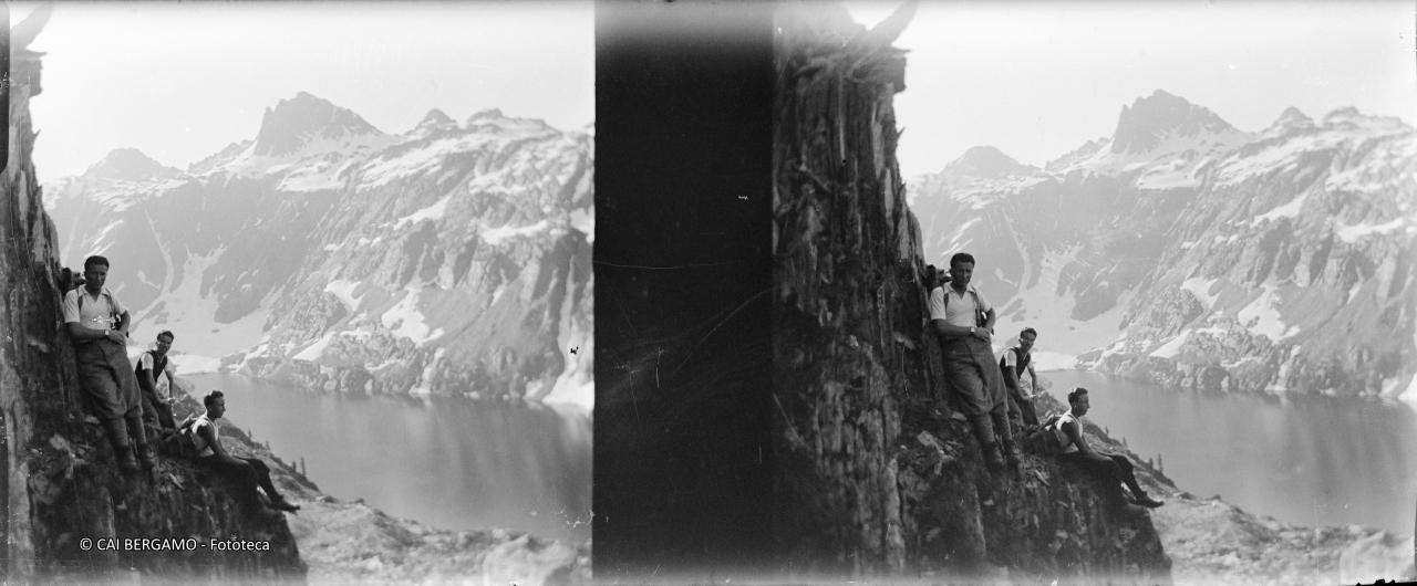 Sosta su parete scoscesa su lago e con cime circostanti con rimasugli di neve