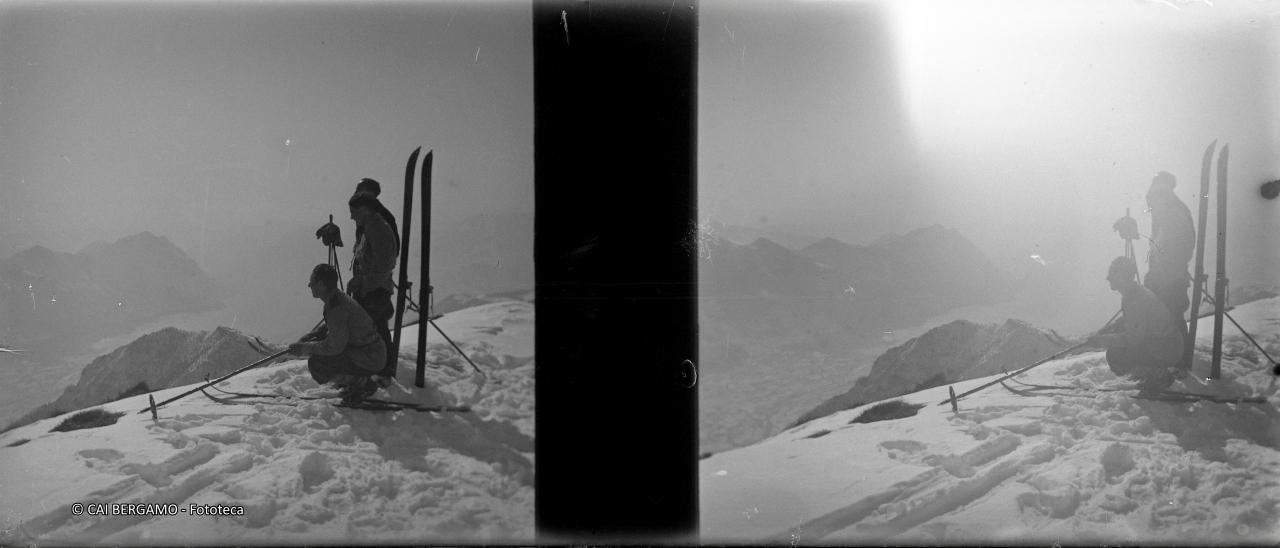 Accovacciati ed in piedi sugli sci con sguardo sul lago d'iseo