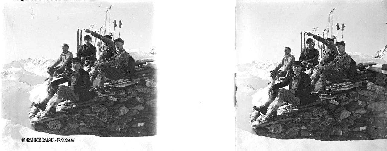 Foto ricordo su tetto baita, comodamente seduti e sci ritti alle loro spalle