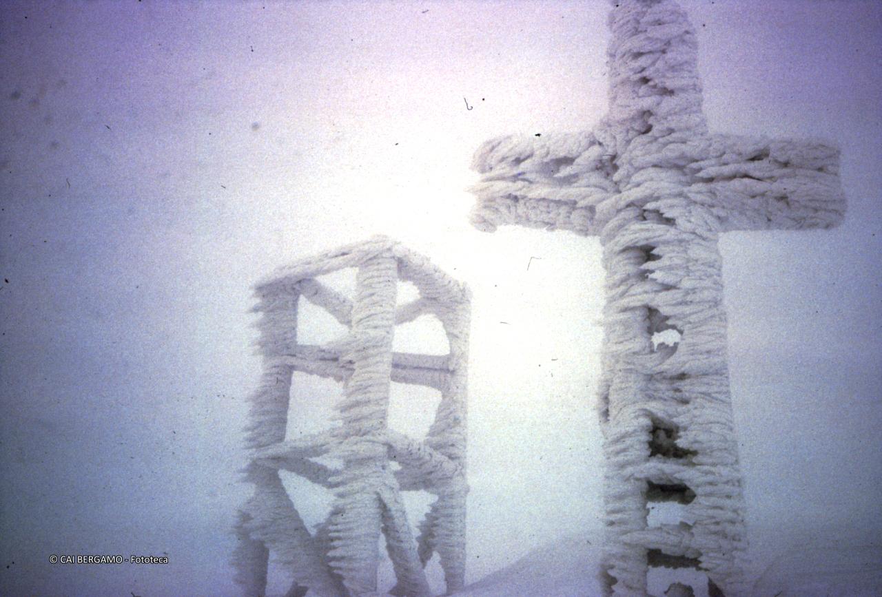 La croce del pizzo Arera ricoperto di neve e ghiaccio