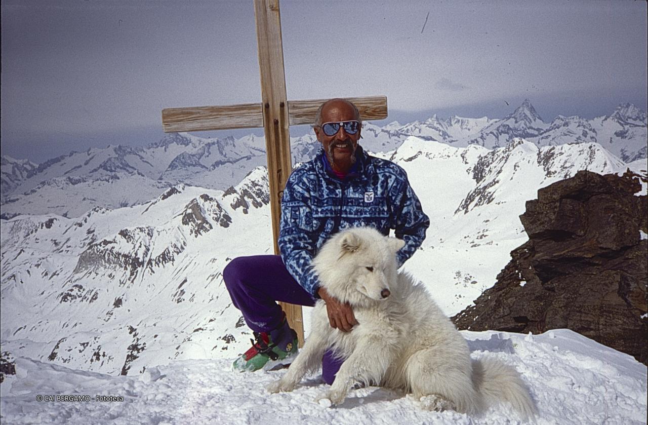 In vetta sulla Punta d'Arbola con il cane e cime circostanti oltre la croce in legno