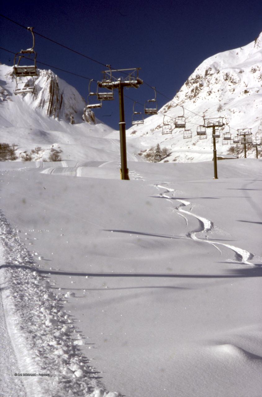 Ziga zag in neve fresca sotto l'impianto di risalita Siltri, con vista sul passo di San Simone con le "canne d'organo"