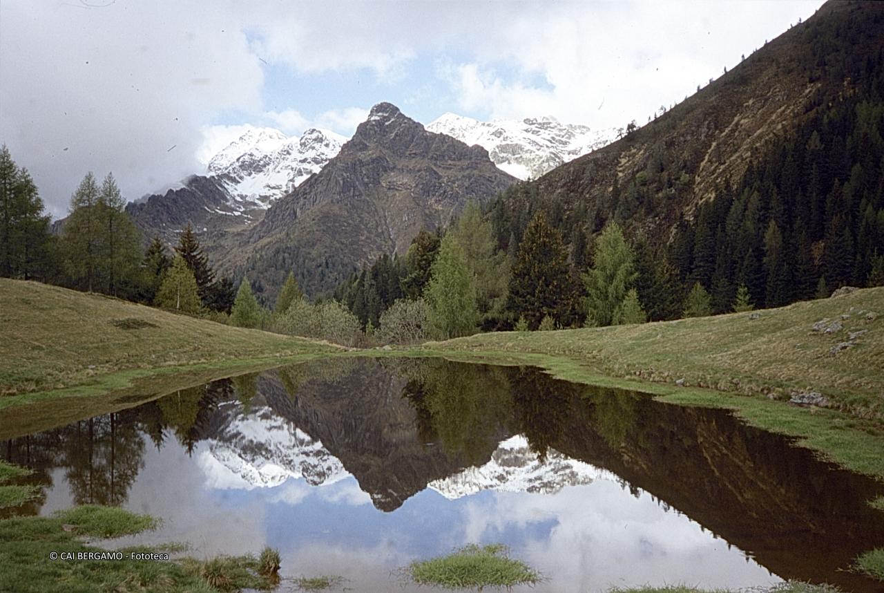 Monte Avaro e retrostante Pizzo di Trona innevato, specchiati nel lago della Casera