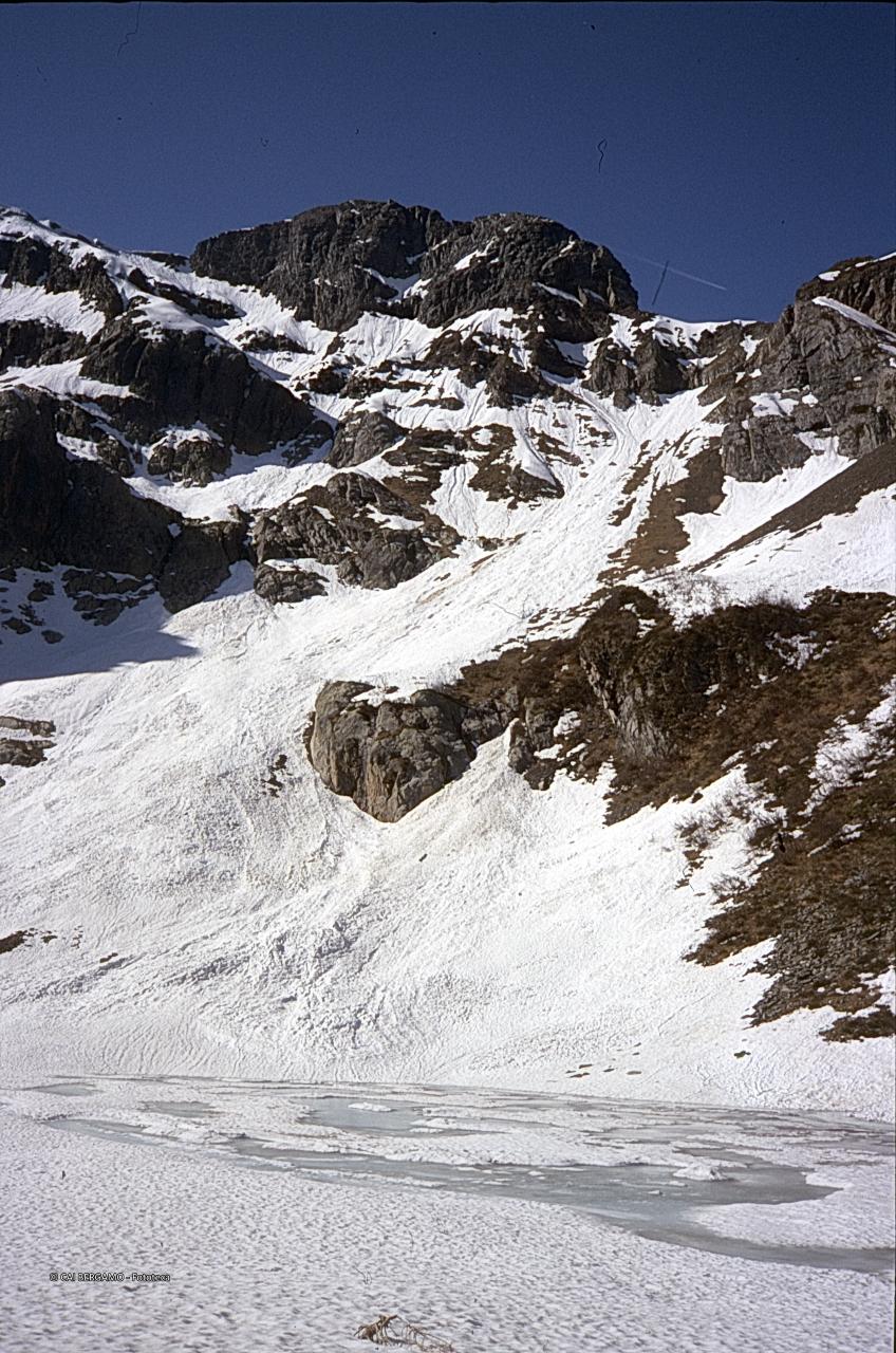 Il Lago Zelto con residui delle valanghe sotto il Valrossa