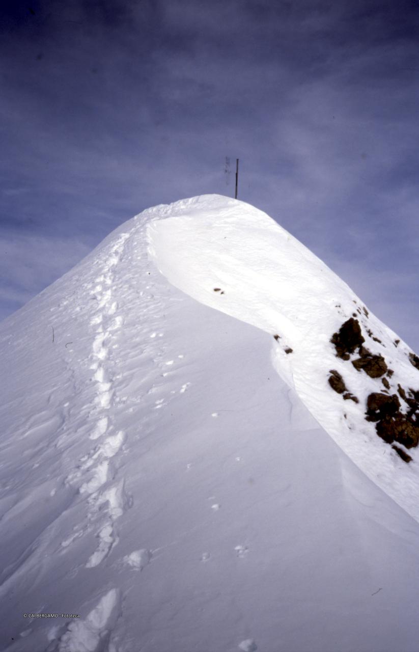 Ultimo tratto in cresta innevata con vista sulla croce in vetta al Piz Ursera