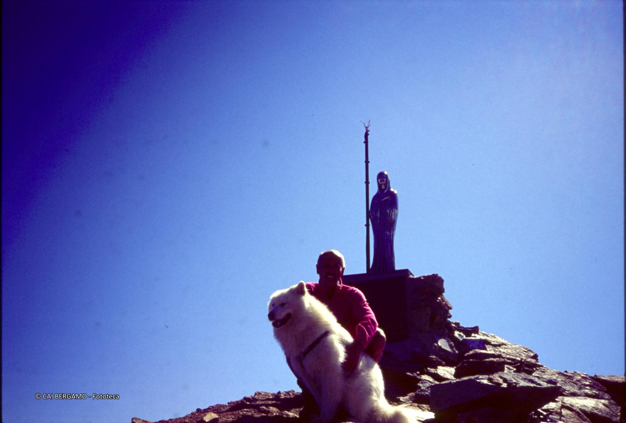 Pezzotta e cane in cima al Monte Emilius davanti alla statua della Madonna